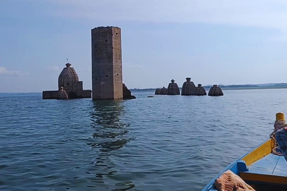 Partially submerged Bathu Temples rising from reservoir water with surrounding hills in Himachal Pradesh 