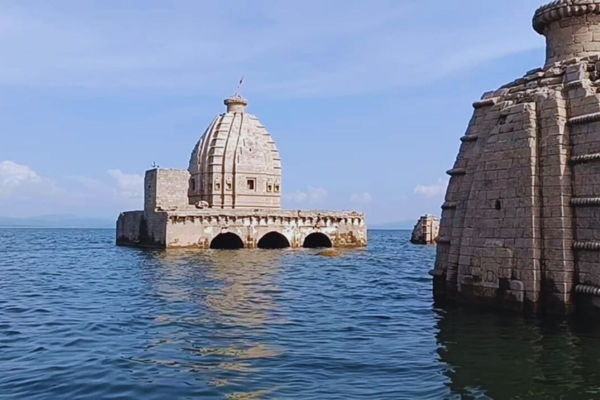 Partially submerged Bathu Temples rising from reservoir water with surrounding hills in Himachal Pradesh 