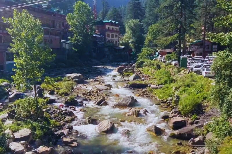 "Spring blossoms in Kasol during March with clear skies and mountain backdrop"