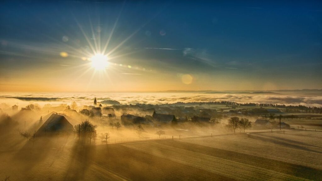 "A Himachal village disappearing into clouds at sunset"