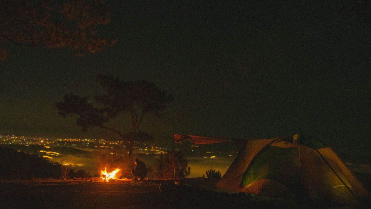 Campers enjoying bonfire under a starry sky in Parvati Valley
