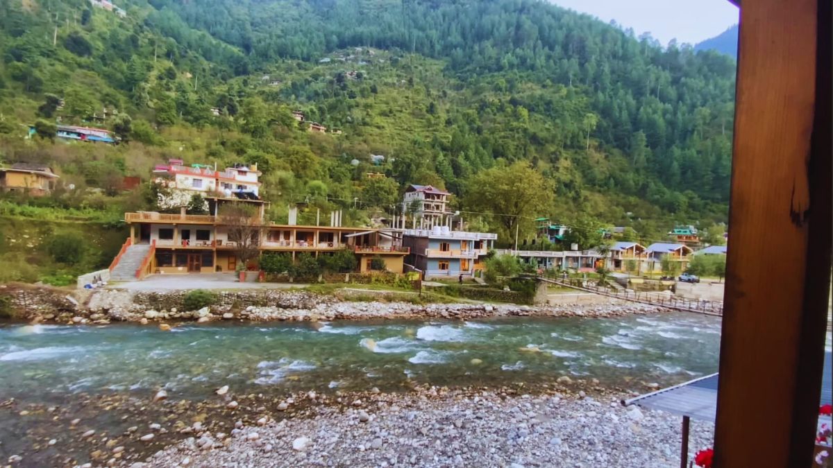 Himachal Honeymoon Destinations Couple relaxing near a riverside homestay in Tirthan Valley